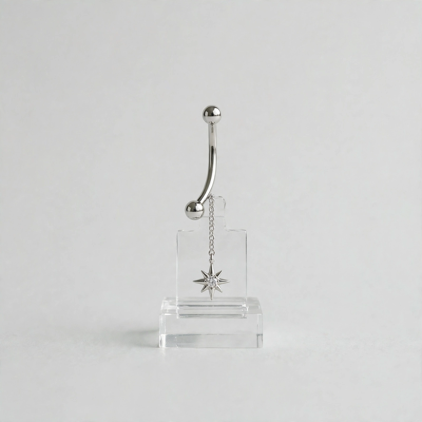 Illustrative styling image of a dangling belly button ring
