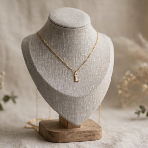 Illustrative styling image of a dainty initial letter pendant necklace on a display stand