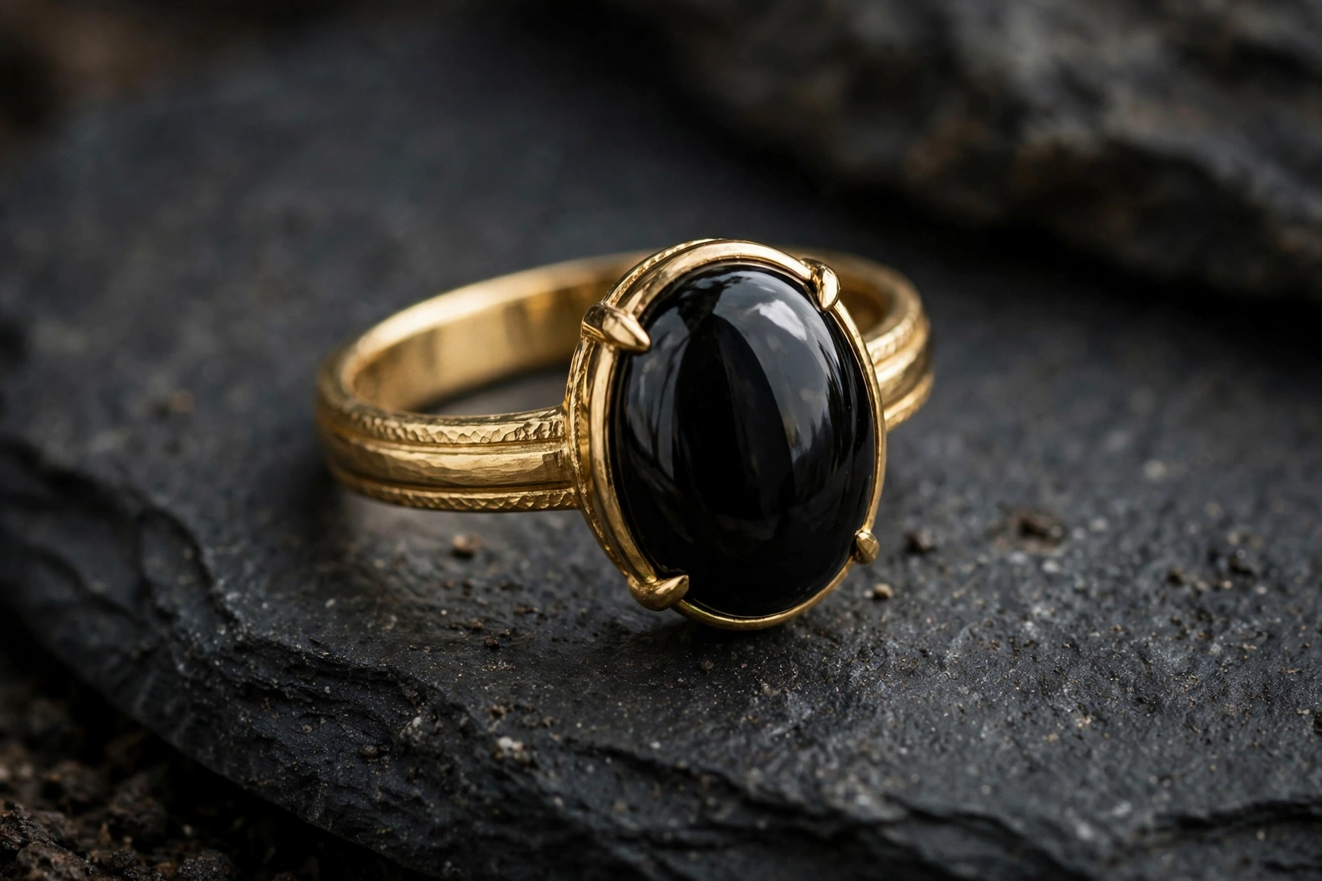 Illustrative styling image of a gold ring with a black onyx stone on dark stone